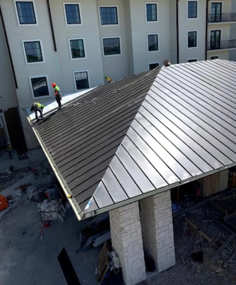Crew installing standing seam metal roof panels on a commercial project in North Fort Myers